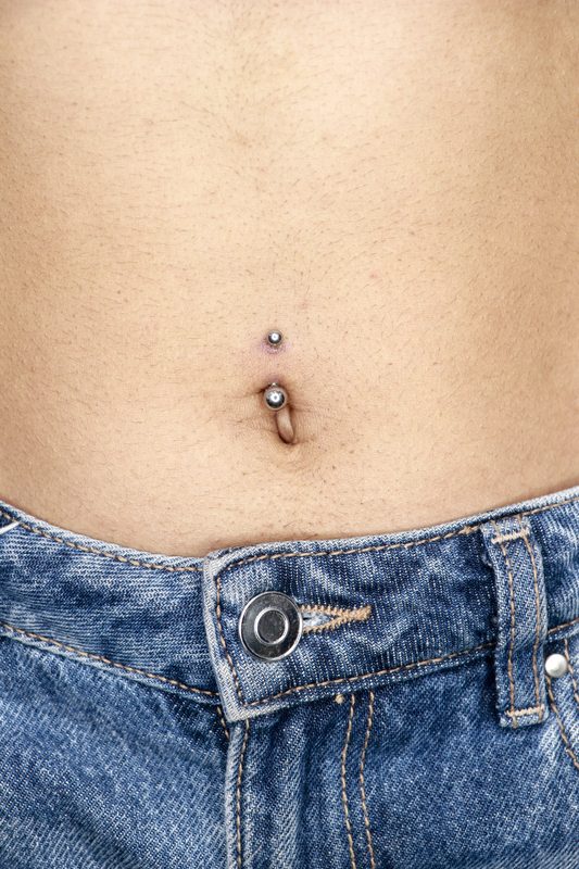 Navel piercing with silver ball captive ring