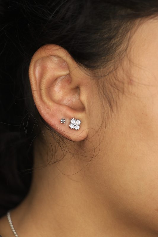 Lobe ear piercing with cluster and star studs