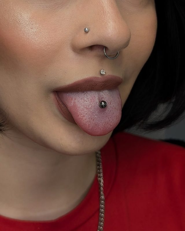 Tongue piercing with black ball barbell