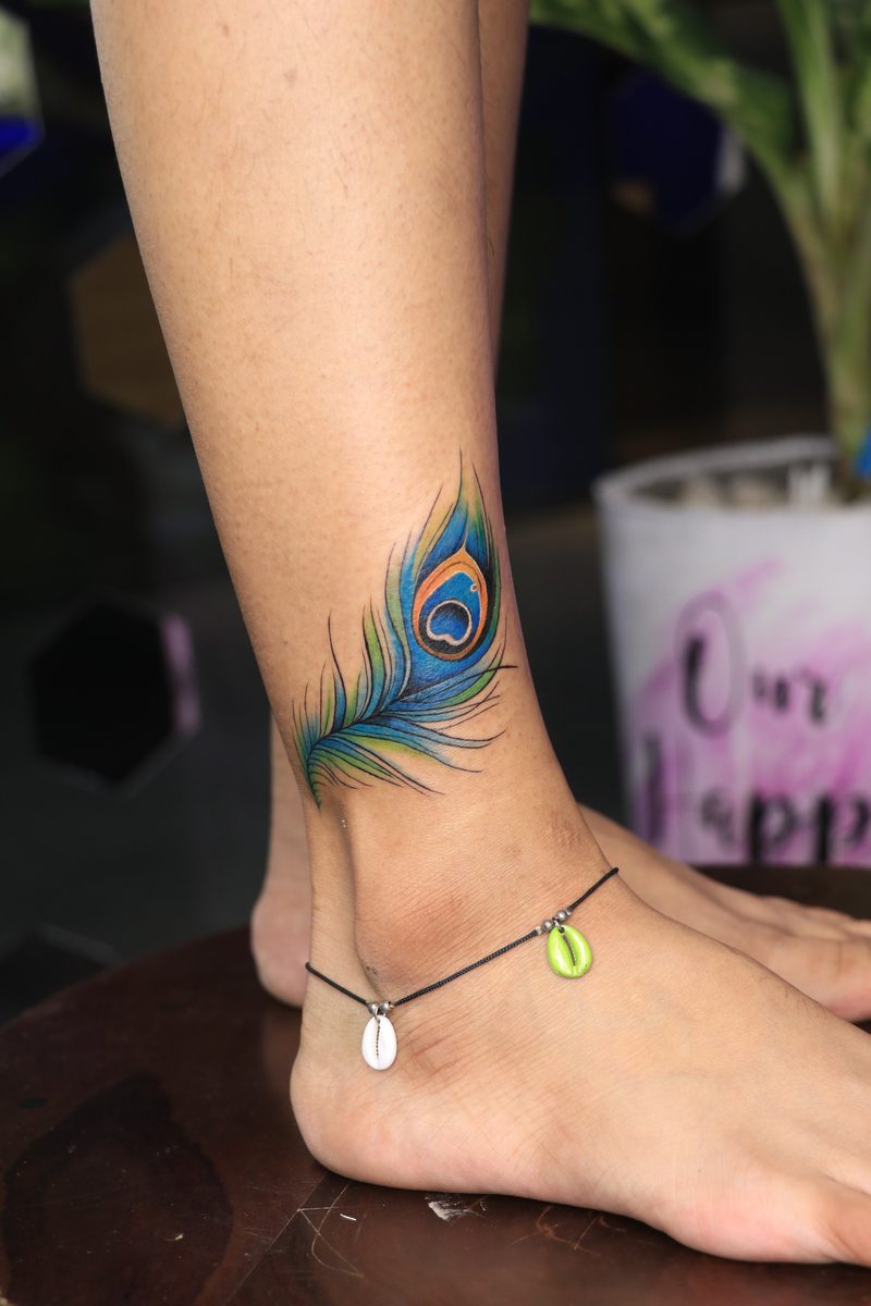 Peacock feather ankle color tattoo