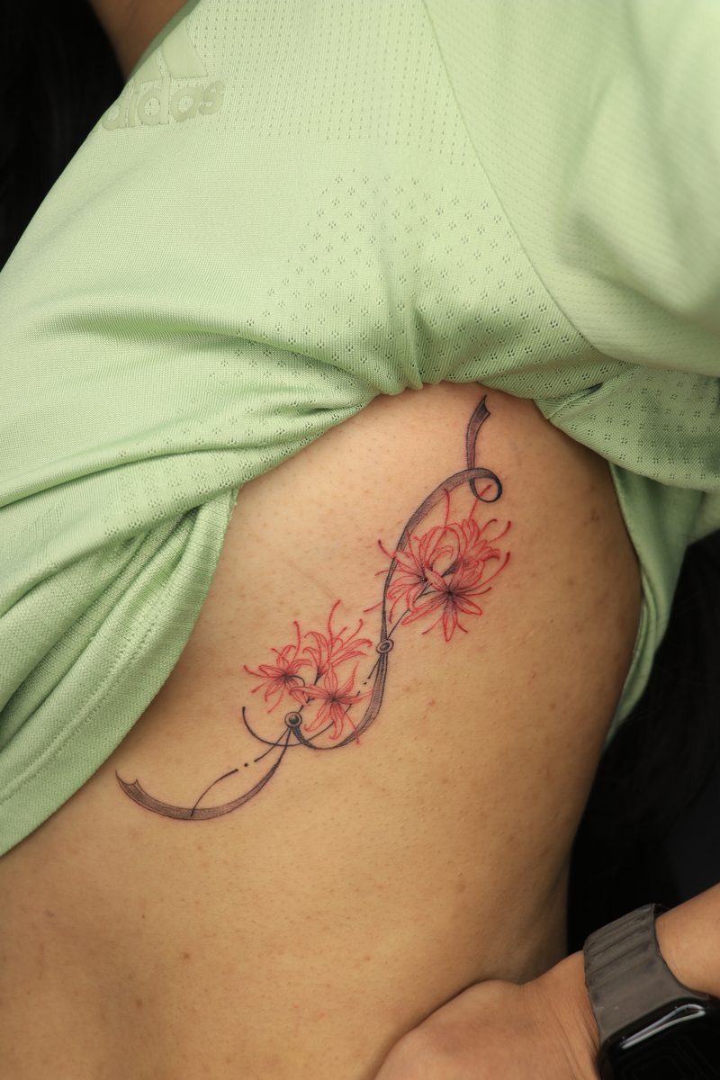Red spider lily flowers rib tattoo