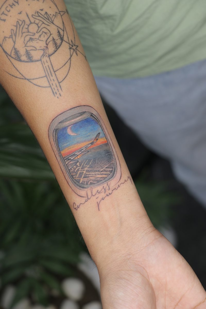 Airplane window view endless journey color tattoo