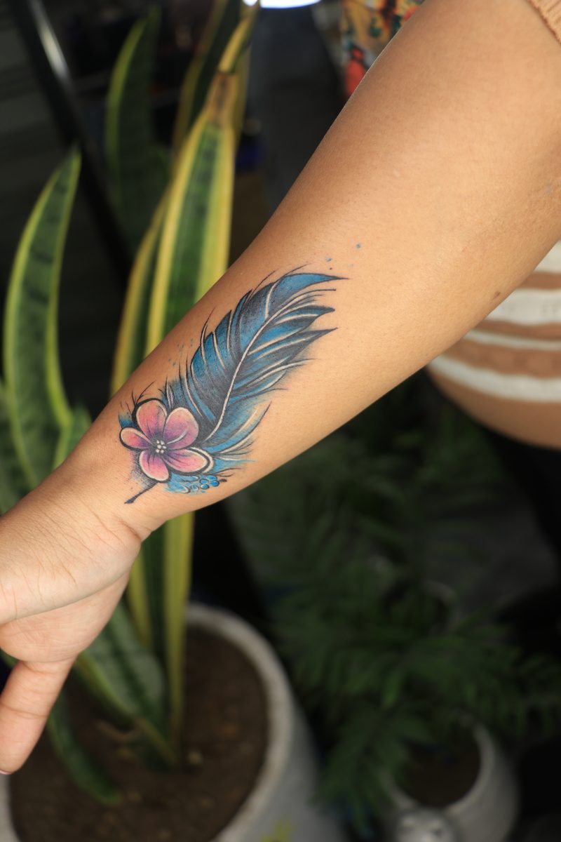 Blue feather with pink flower color tattoo