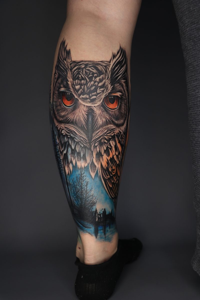 Owl with orange eyes night forest leg tattoo