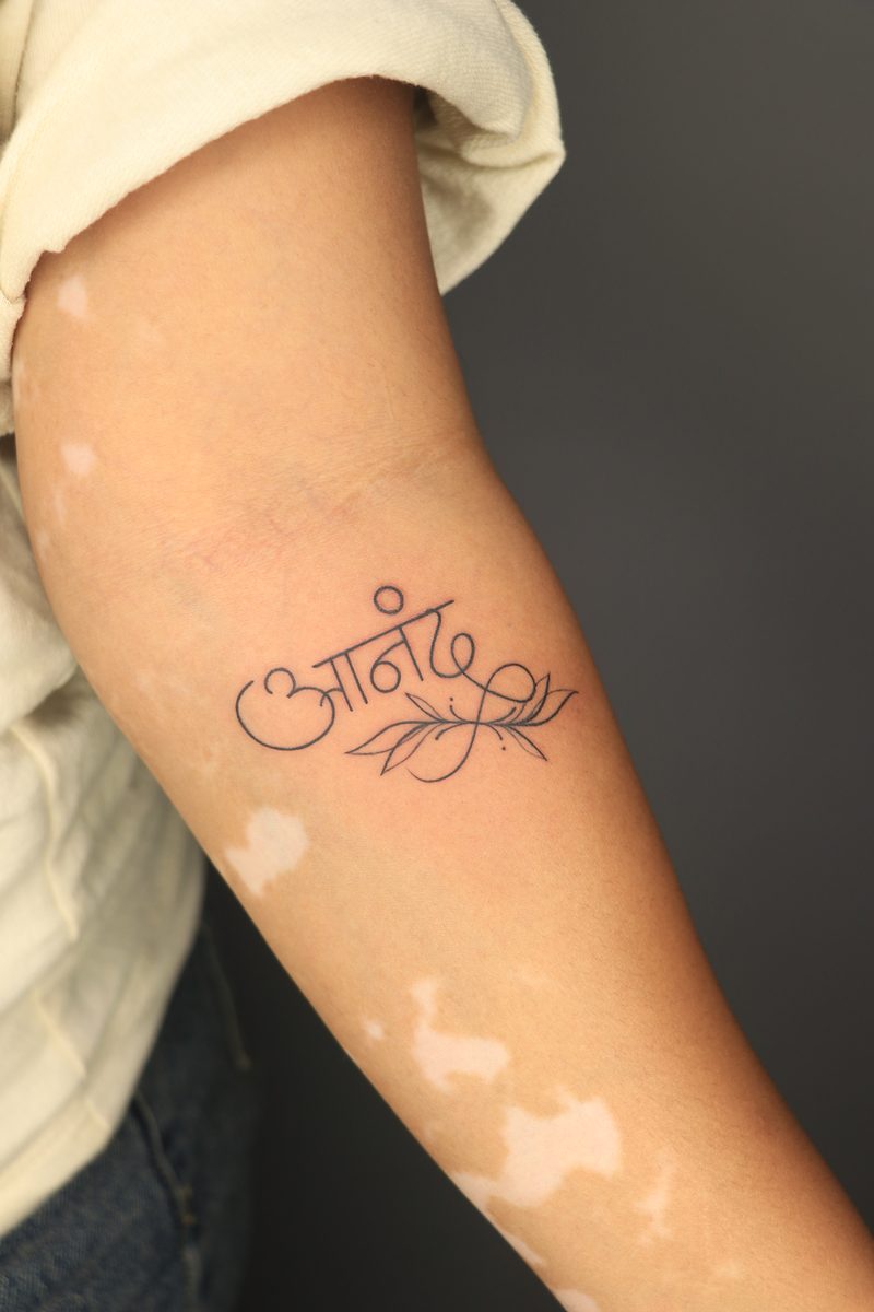 Anand hindi calligraphy fine line tattoo with leaves