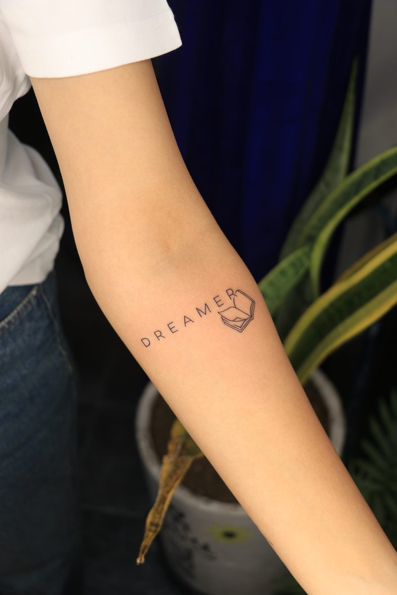 Dreamer with open book fine line tattoo