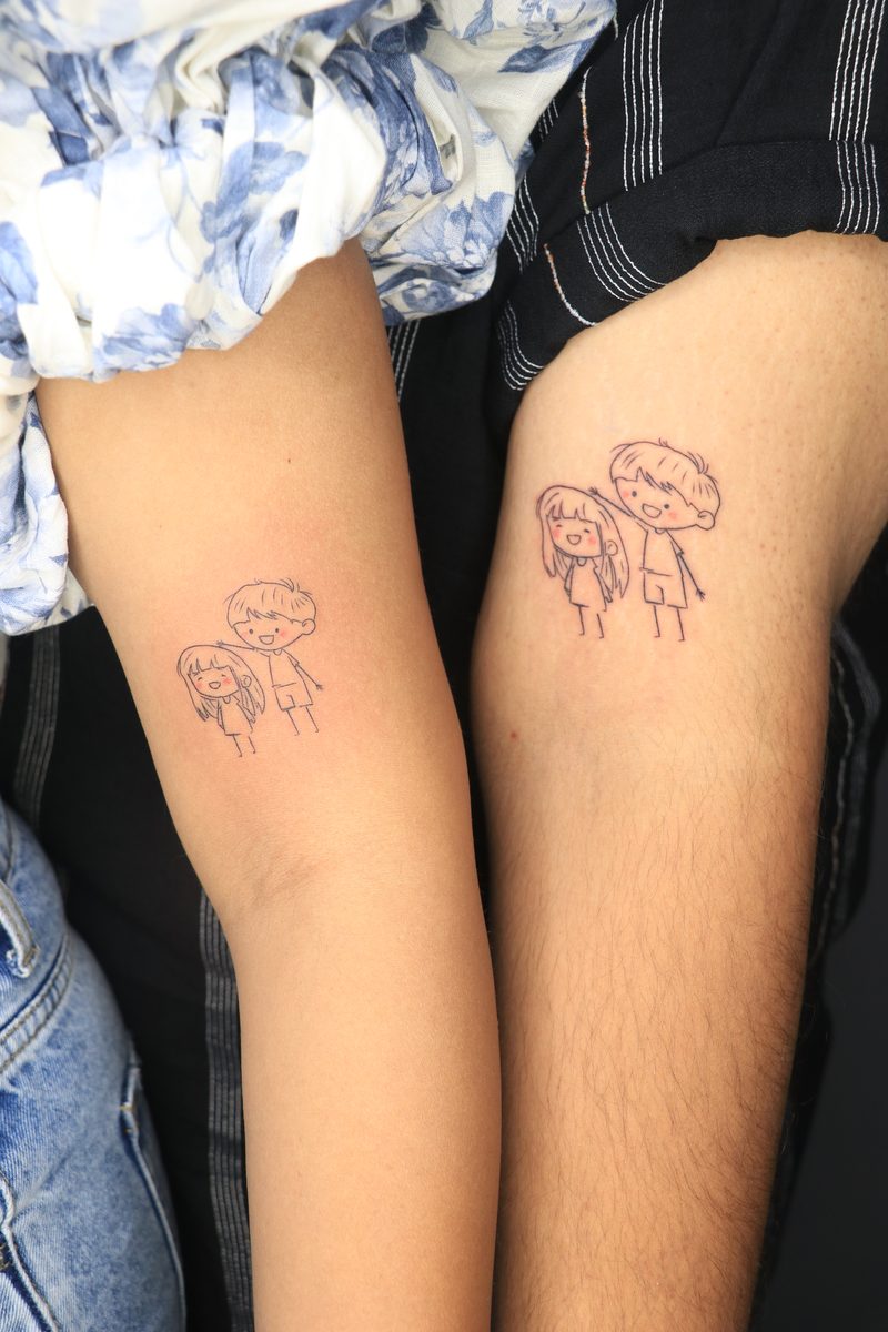 Matching cartoon couple fine line tattoos