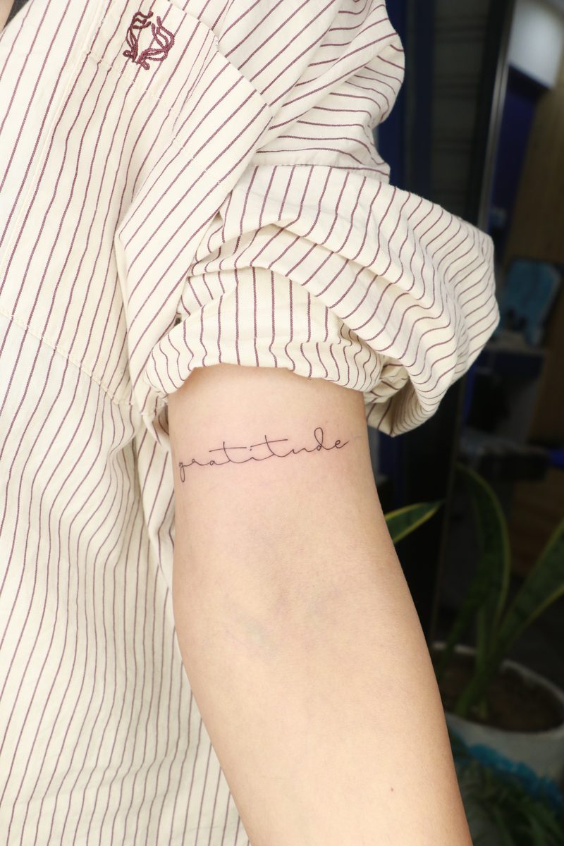 Gratitude cursive fine line tattoo