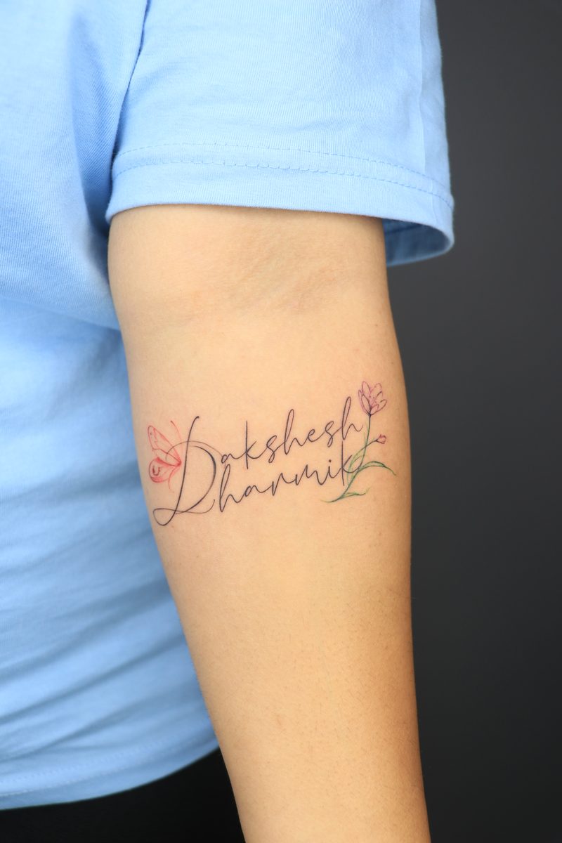 Name calligraphy tattoo with butterfly and flower