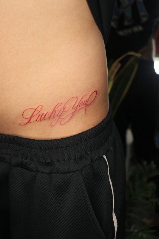 Lucky You red ink calligraphy script tattoo