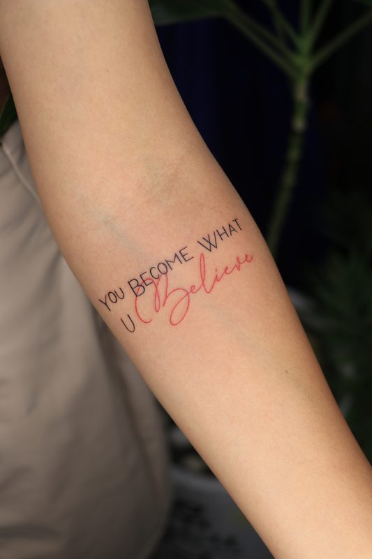 You become what u believe red and black script tattoo