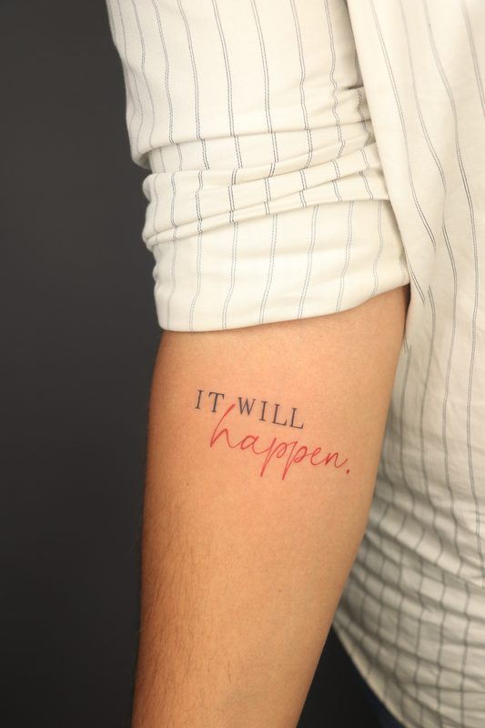 It will happen red and black script tattoo on arm
