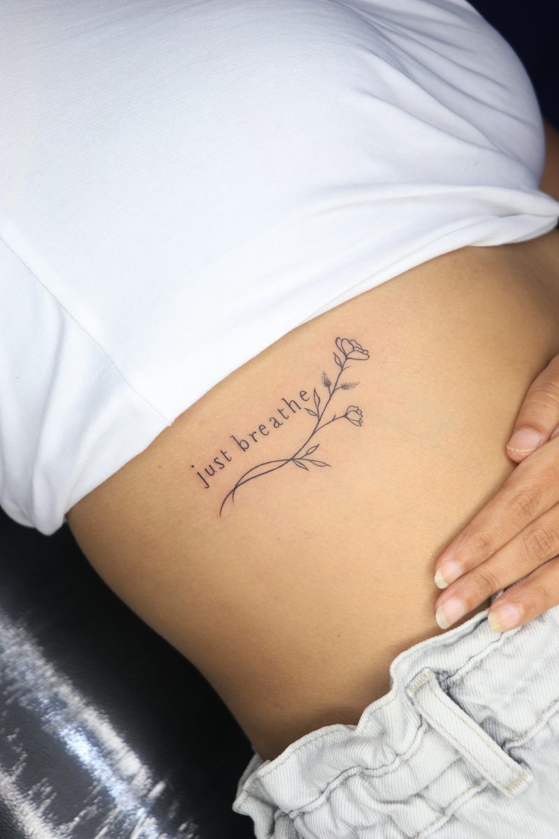 Just breathe script tattoo with flowers